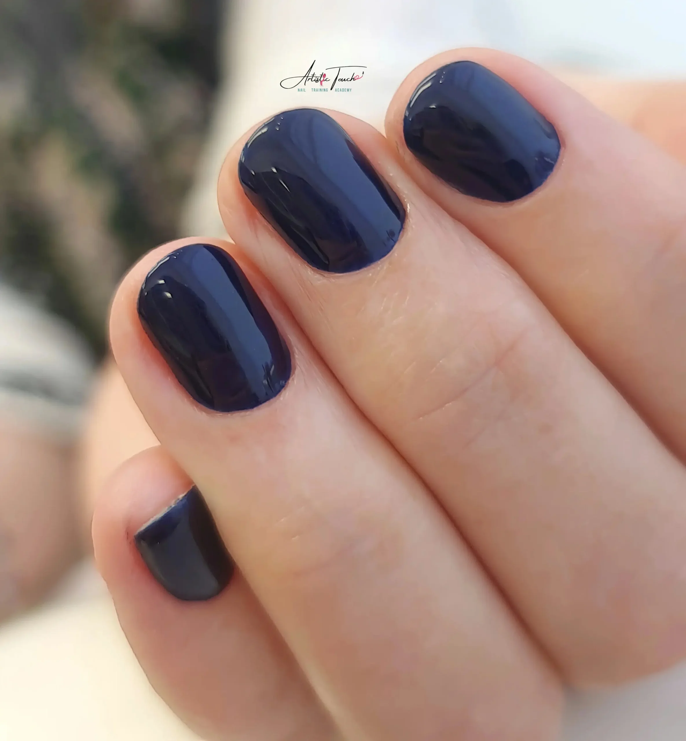 Professional e-file manicure with navy gel polish showing clean cuticle work and smooth finish