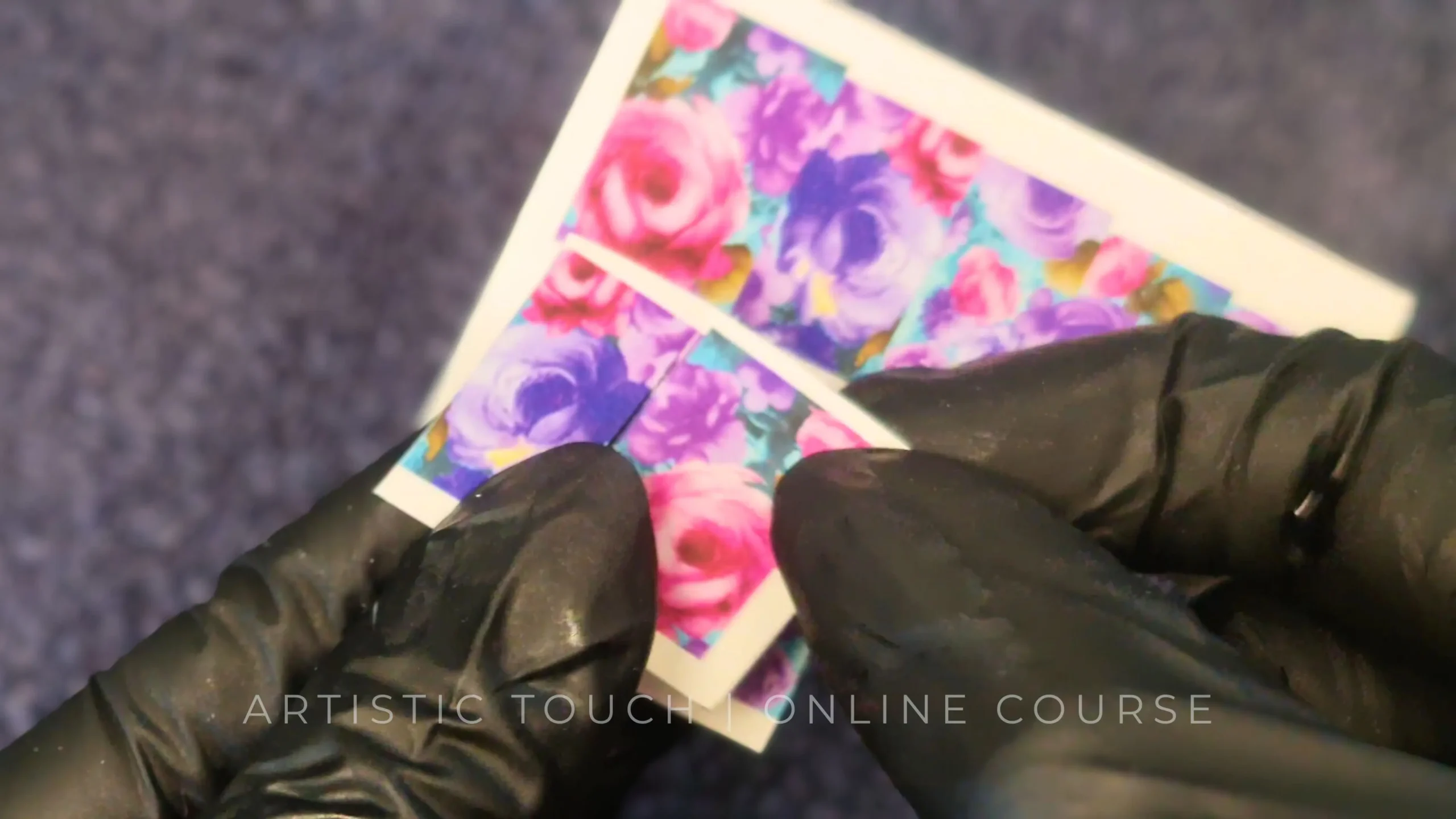Course screenshot showing hands with gloves holding water decals and explaining professional application technique