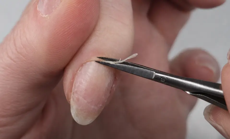 Precision cuticle removal using professional manicure scissors during Russian Manicure